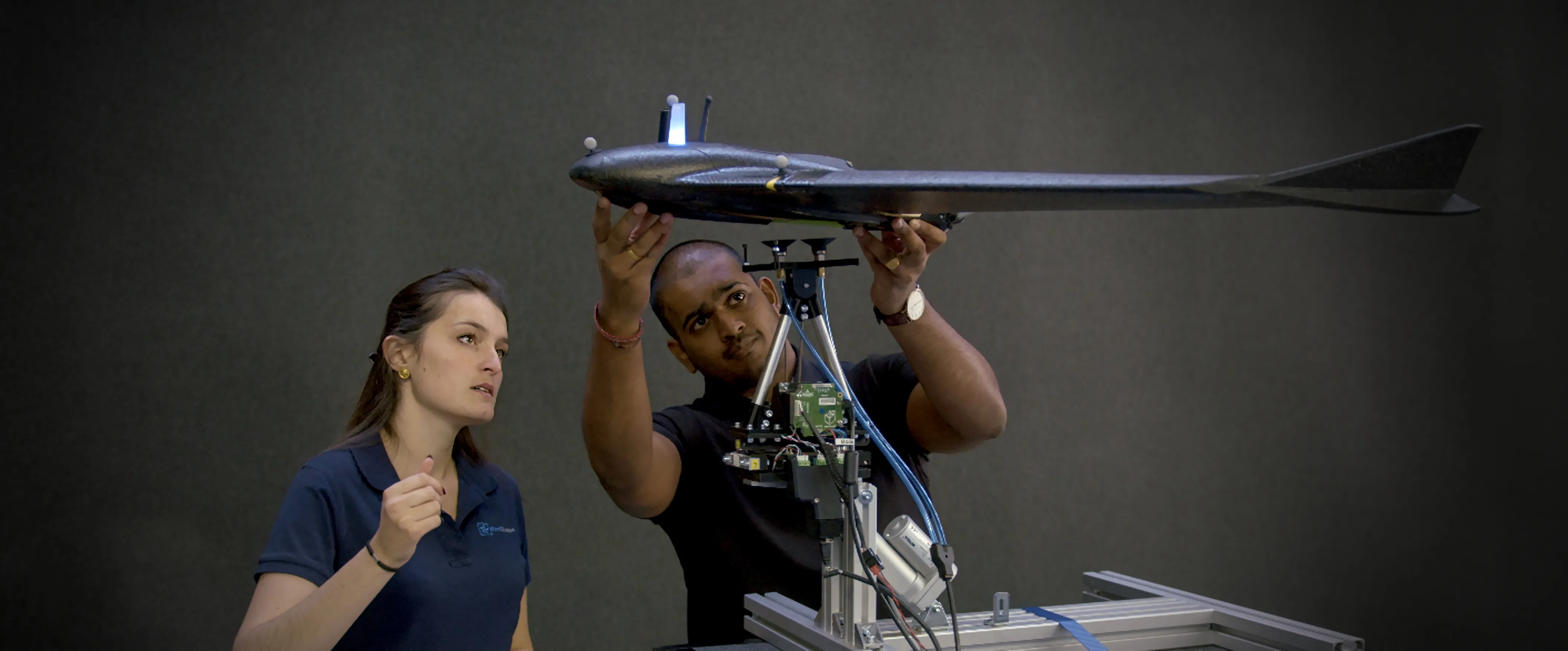 Engineers preparing a fixed-wing drone for a free-flight test in a WindShaper environment